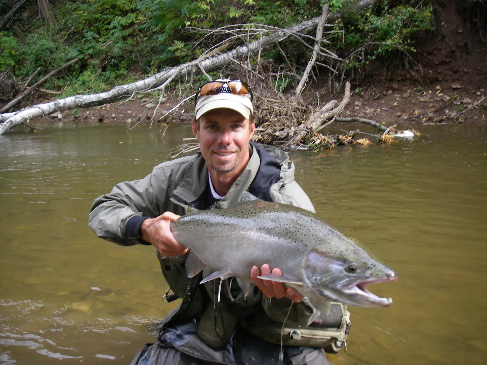 An angler holding a bright steelhead in Bronte Creek