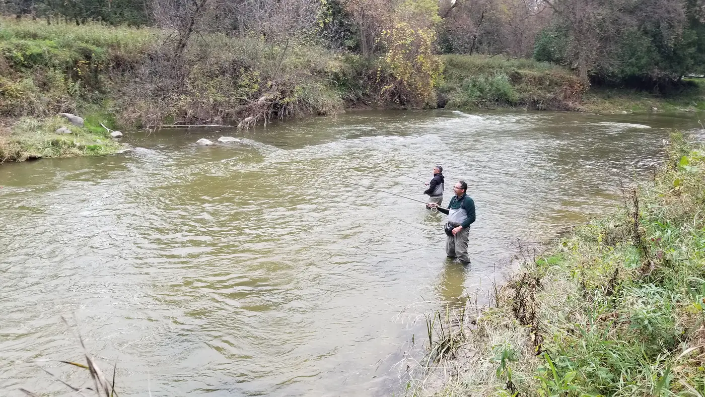 Two anglers float fishing with centerpin rods in a wide river bend