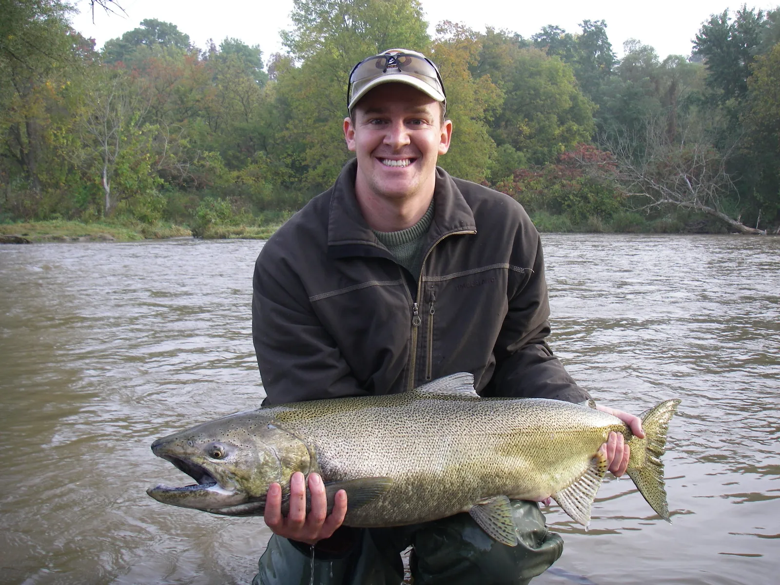 An angler holding a large chinook salmon in the Lower Credit River